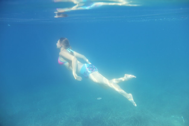 Mulher nadando debaixo d'água no mar Adriático Mediterrâneo, na Croácia