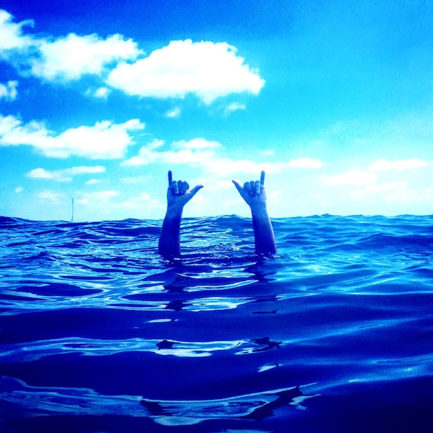 Mulher nadando no mar contra o céu azul