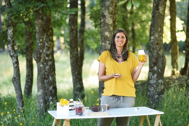 Mulher naturopata com plantas medicinais na mesa de trabalho ao ar livre