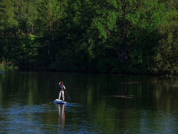 Mulher navegando na bela lagoa verde calma. Viagem de férias de férias de verão. SUP stand up paddle board