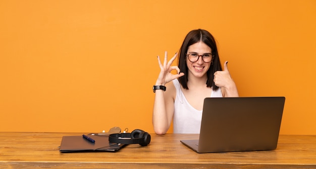 Mulher negócio, em, um, escritório, mostrando, tá bom sinal, e, polegar cima, gesto