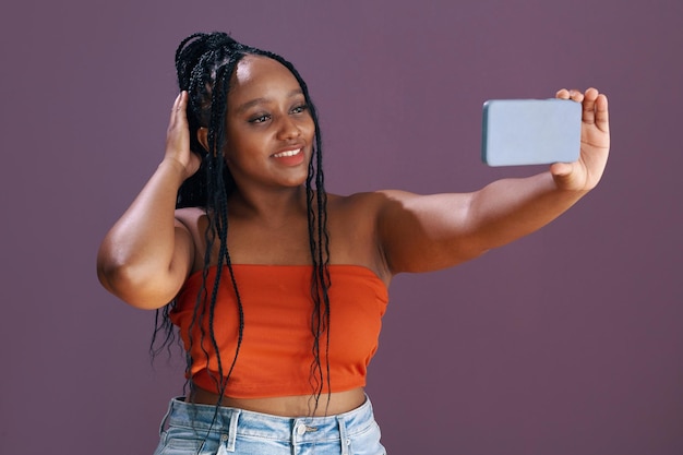 Foto mulher negra a tirar uma selfie.
