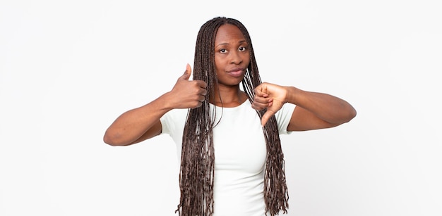 Mulher negra adulta afro se sentindo confusa, sem noção e insegura, ponderando o que é bom e o que é mau em diferentes opções ou escolhas