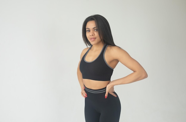Mulher negra afro-americana atraente em leggings coloridas e roupa de fitness superior