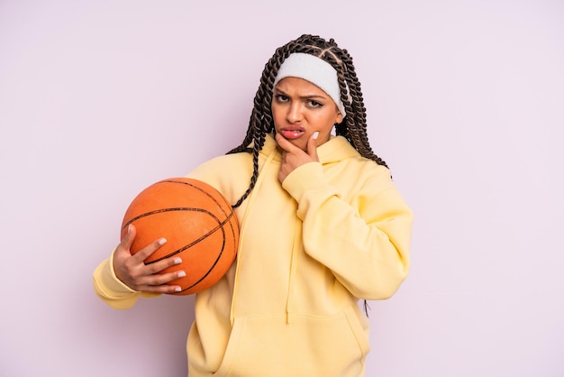 mulher negra afro com boca e olhos bem abertos e mão no queixo. conceito de basquete