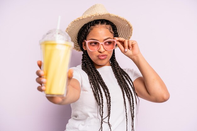 Mulher negra afro com tranças com um milk-shake. conceito de verão