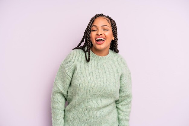 Mulher negra afro com um grande sorriso amigável e despreocupado parecendo positivo relaxado e feliz esfriando