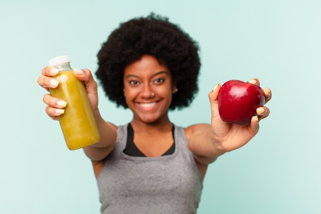 Mulher negra afro-fitness com smoothy