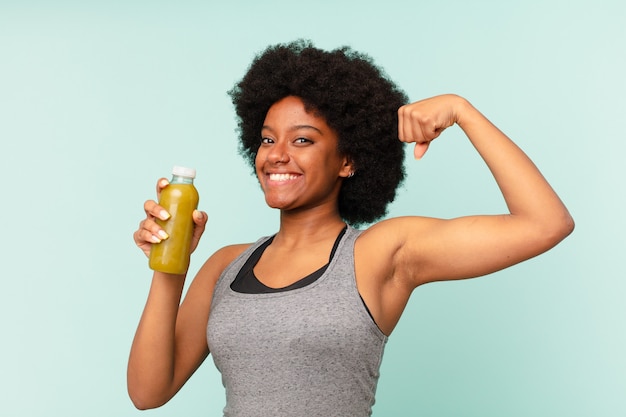 Mulher negra afro-fitness com smoothy