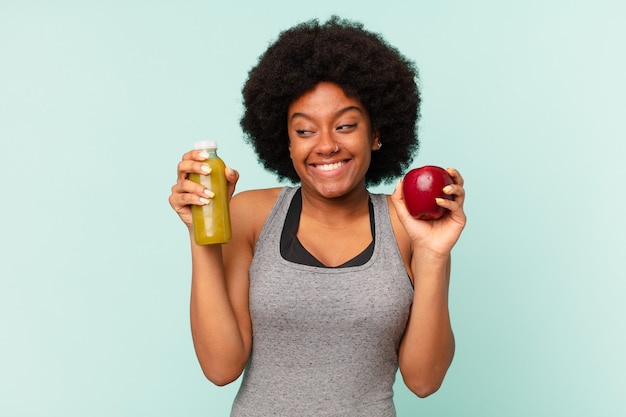 Mulher negra afro-fitness com smoothy