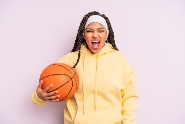 Mulher negra afro gritando agressivamente, parecendo muito zangada. conceito de basquete