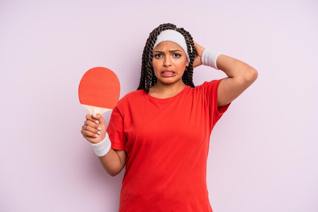 Mulher negra afro se sentindo estressada, ansiosa ou assustada, com as mãos na cabeça. conceito de pingue-pongue