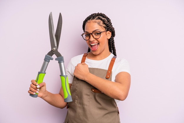 Mulher negra afro se sentindo feliz e enfrentando um desafio ou celebrando o conceito de jardineiro ou agricultor