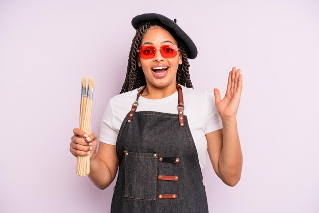 Mulher negra afro se sentindo feliz e surpresa com algo inacreditável. conceito de artista