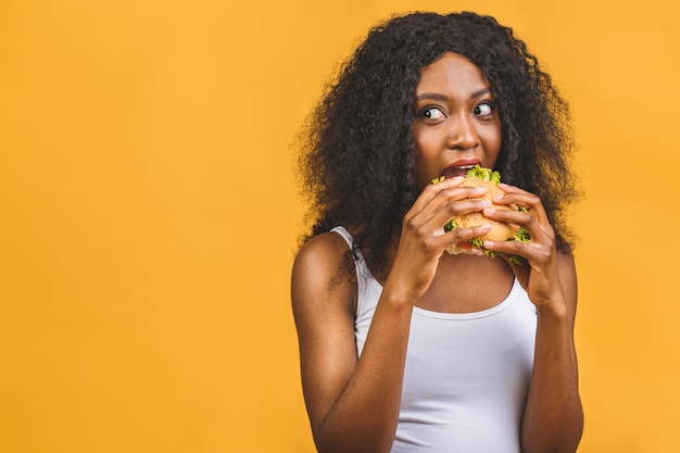 Mulher negra bonita afro-americana comendo hambúrguer