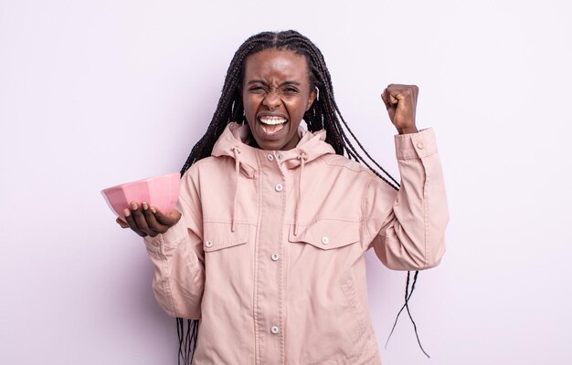 Foto mulher negra bonita gritando agressivamente com uma expressão de raiva. conceito de tigela vazia