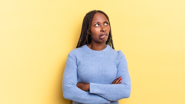 Mulher negra bonita negra duvidando ou pensando, mordendo o lábio e sentindo-se insegura e nervosa, procurando copiar espaço ao lado