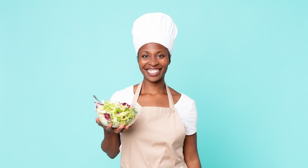 Mulher negra chef adulta afro-americana segurando uma salada