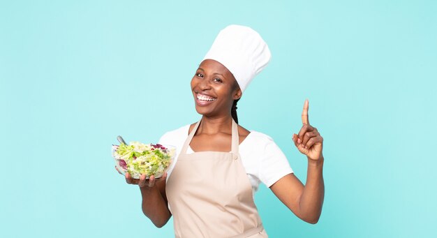 Mulher negra chef adulta afro-americana segurando uma salada