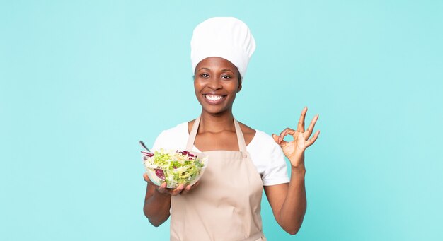 Mulher negra chef adulta afro-americana segurando uma salada