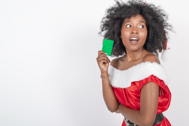 Mulher negra chocada em uma fantasia de natal com um gesto facial de cartão verde