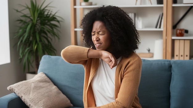 Mulher negra com vírus da gripe a espirrar no cotovelo na sala de estar