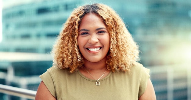 Mulher negra de negócios e retrato da cidade enquanto feliz ao ar livre com visão e orgulho Rosto de empresário com prédios urbanos e motivação para objetivos de carreira como futuro líder com um sorriso