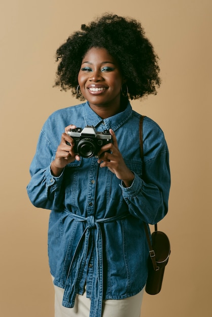 Foto mulher negra de tiro médio com câmera fotográfica