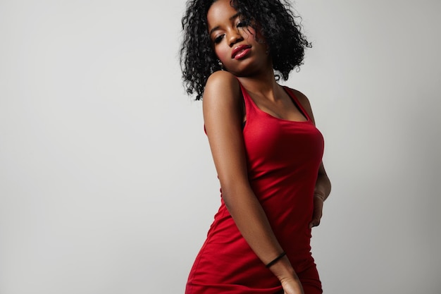 Mulher negra de vestido vermelho, mostrando o corpo de beleza