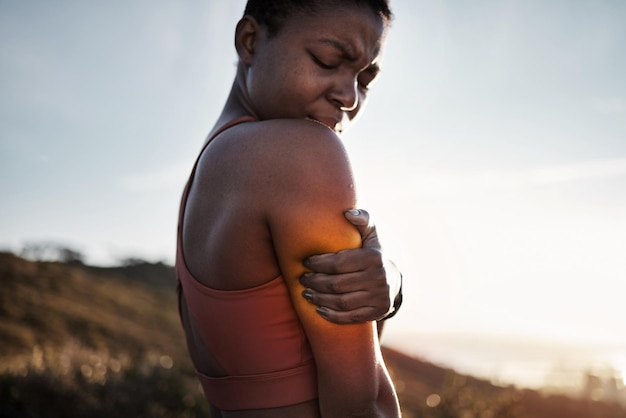 Foto mulher negra esportes fitness e dor no braço após acidente de exercício ao ar livre saúde do pôr do sol e jovem atleta com inflamação de lesão muscular ou fibromialgia após treino intenso ou treinamento