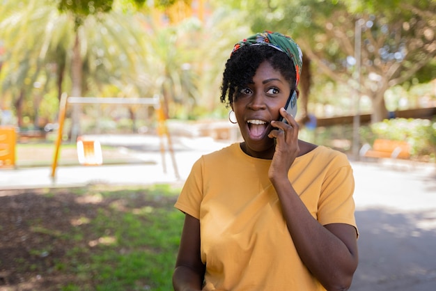 Mulher negra falando no celular surpresa