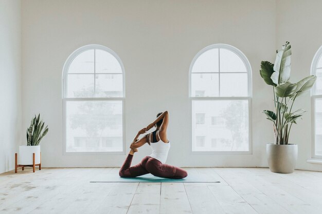 Mulher negra fazendo pose de Naginyasana