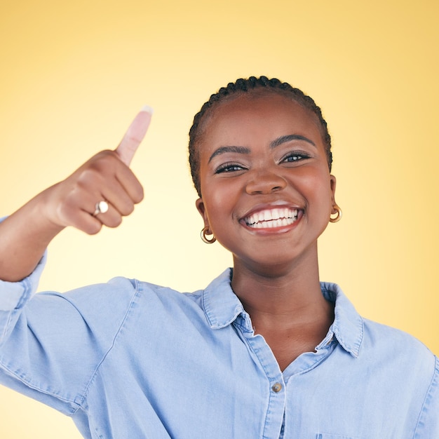 Mulher negra feliz em retrato e polegares para cima feedback e apoio isolado em fundo amarelo Feliz acordo e gesto com a mão com revisão positiva sim e como emoji com sucesso em um estúdio