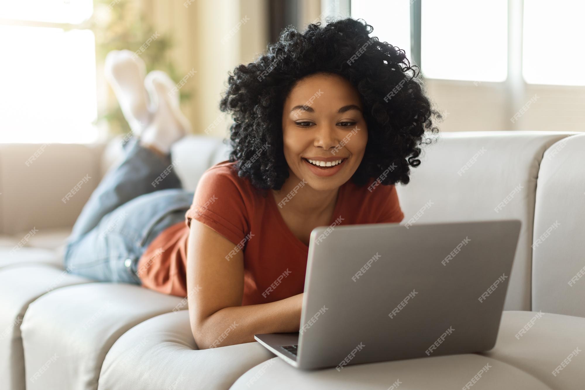 Relaxe a mulher negra no chão e o laptop para uma pausa na