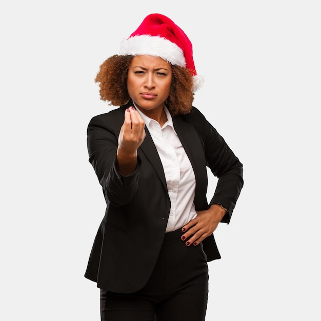 Mulher negra jovem negócios usando um chapéu de papai noel chirstmas fazendo um típico gesto italiano