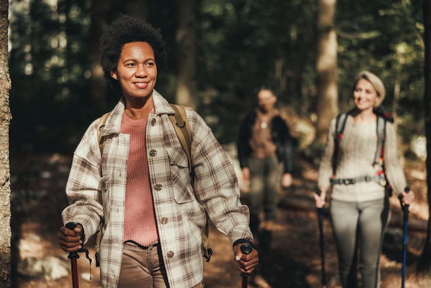 Mulher negra madura caminhando pelas montanhas com seus amigos.