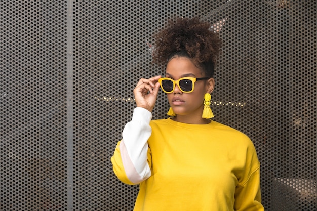 Mulher negra moderna com óculos de sol amarelos
