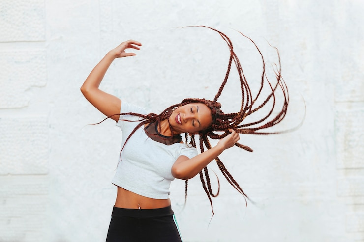 Foto mulher negra, movendo-se com ritmo suas longas tranças