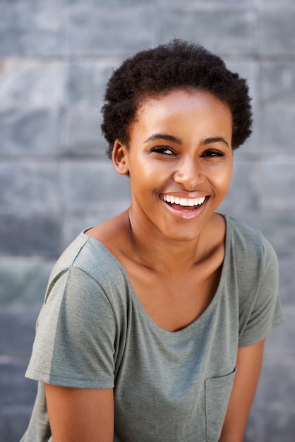 Mulher negra nova atrativa que sorri com t-shirt