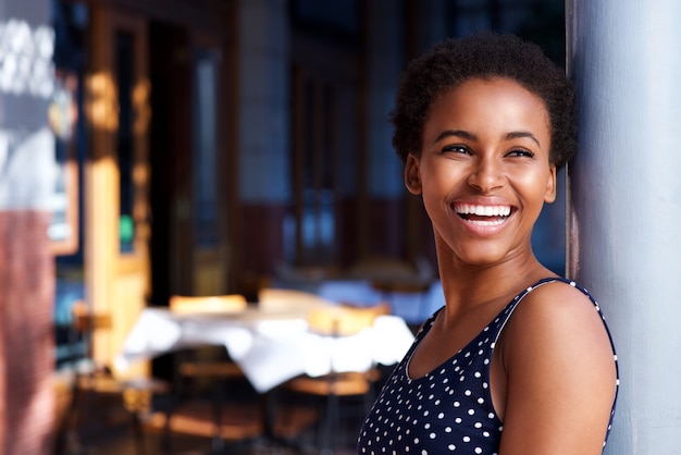 Mulher negra nova de sorriso que está fora