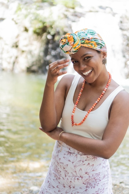 Mulher negra posa com confiança usando lenço colorido