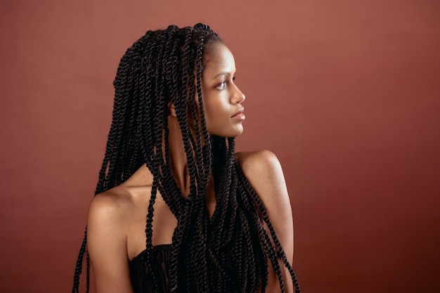 Mulher negra sentada com tranças afro à luz