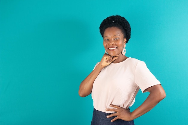 Mulher negra sorrindo e fazendo um gesto com fundo verde