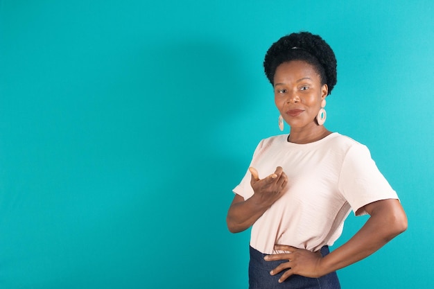 Mulher negra sorrindo e fazendo um gesto com fundo verde