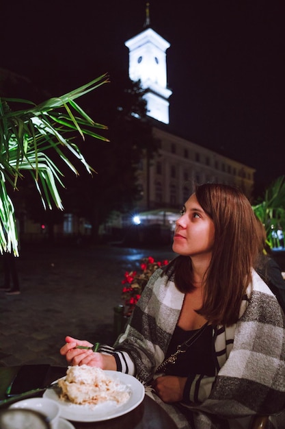 Mulher no café ao ar livre à noite