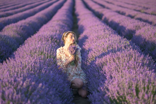 Mulher no campo de lavanda ao pôr do sol, vestido de verão