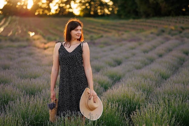 Mulher no campo de lavanda ao pôr do sol