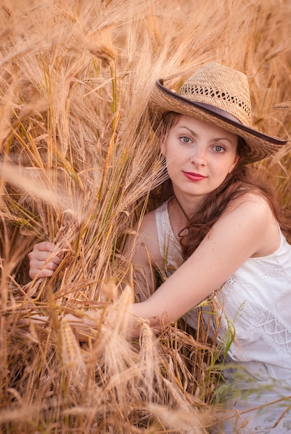 Mulher no campo de trigo, agricultora com safra