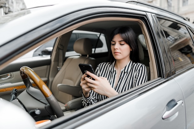 Mulher no carro usa telefone