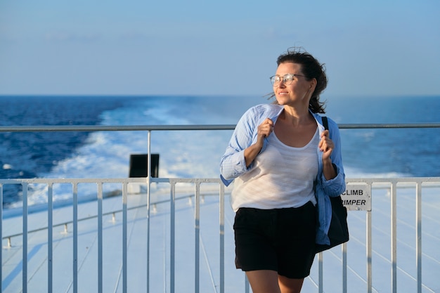 Mulher no convés da balsa, mulher em pé sob forte vento